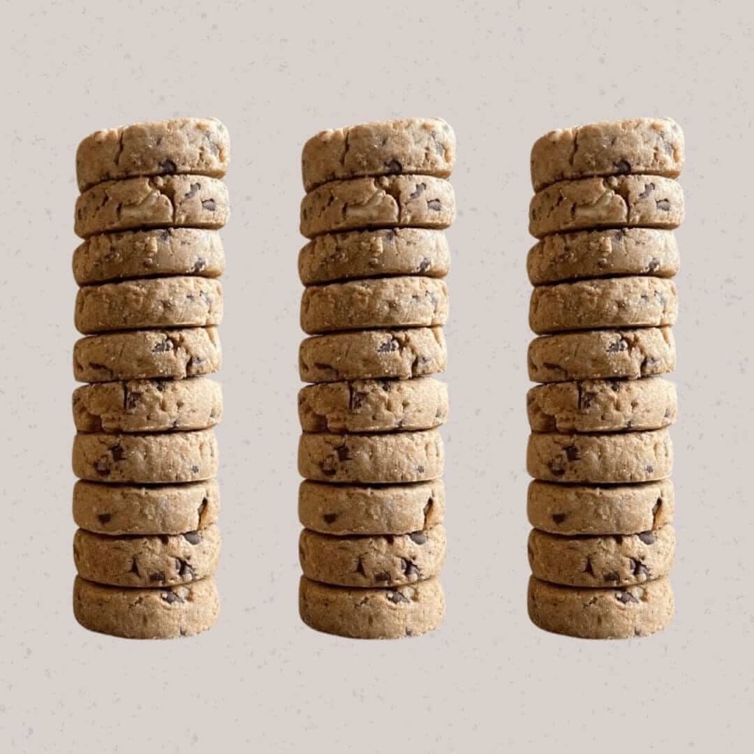 Stacked hazelnut dark chocolate cookies made with 74% Belgian chocolate and whole wheat flour, in compostable packaging by Jane Bakes.
