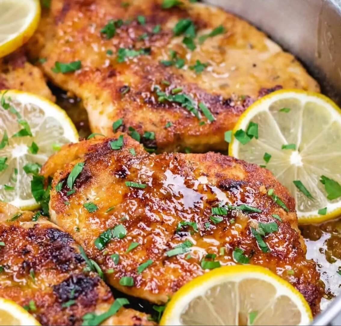 Juicy grilled chicken breast garnished with fresh herbs and lemon slices, prepared with a savory glaze, perfect for a quick main dish.