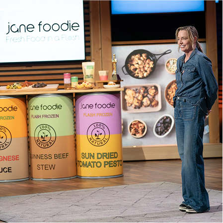 Jane Carroll, founder of Jane Foodie, presenting on Shark Tank Season 16 Episode 16 with branded products on stage.